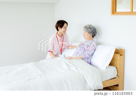 ベッドに座る老人と介護福祉士 116183003