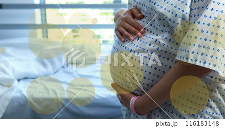 Image of green spots over biracial pregnant woman touching her stomach in hospital 116183148