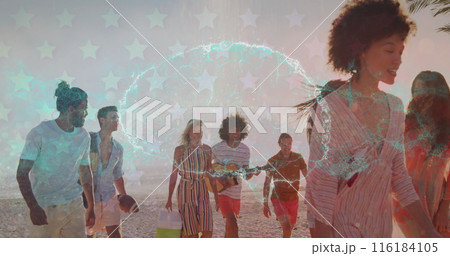A group of friends are enjoying a sunset walk on a tropical beach 116184105