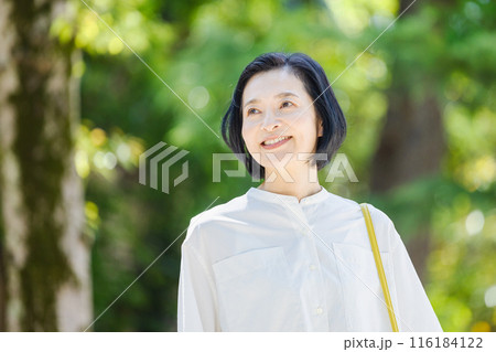 新緑の中を歩くミドル女性 116184122