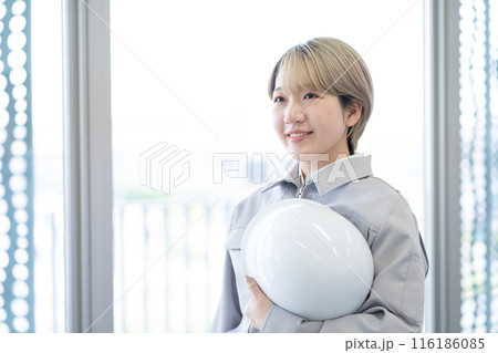 作業服を着てヘルメットを持つ金髪ショートヘアの若い女性（髪色自由、自分らしく働く、職場環境） 116186085