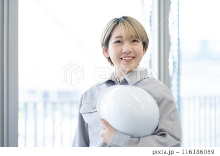 作業服を着てヘルメットを持つ金髪ショートヘアの若い女性（髪色自由、自分らしく働く、職場環境） 116186089