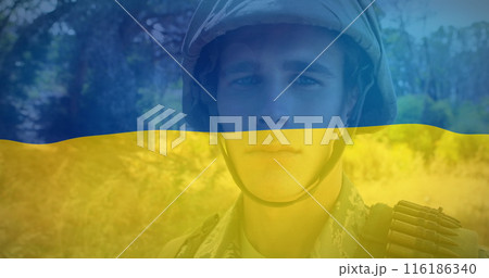 Caucasian young professional wearing military uniform stands before Ukrainian flag Caucasian young professional wearing military uniform stands before Ukrainian flag 116186340