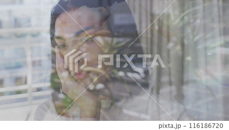 Young Asian woman standing behind window, blending with reflections 116186720