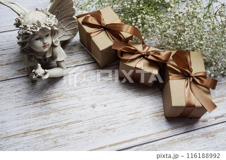 Gift boxes with gold ribbon and flower decoration on wooden background Gift boxes with gold ribbon and flower decoration on wooden background 116188992