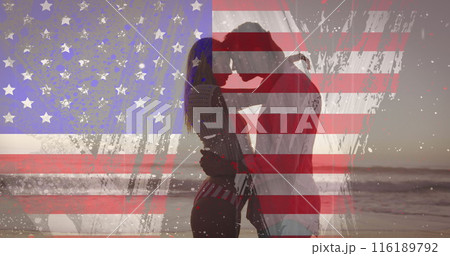 American flag with glitch effect against couple embracing each other at the beach 116189792