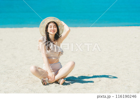 砂浜に座る水着の若い女性 砂浜に座る水着の若い女性 116190246