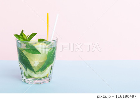 Mojito summer refreshing cocktail with ice and mint. mojito cocktail with lime, lemon and mint in a tall glass with a stick 116190497