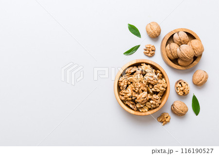 Walnut kernel halves, in a wooden bowl. Close-up, from above on colored background. Healthy eating Walnut concept. Super foods with copy space Walnut kernel halves, in a wooden bowl. Close-up, from above on colored background. Healthy eating Walnut concept. Super foods with copy space 116190527