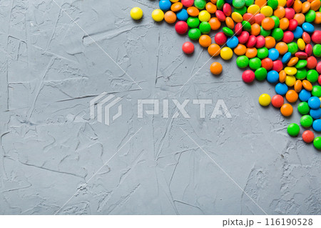 Mixed collection of colorful candy, on colored background. Flat lay, top view. frame of colorful chocolate coated candy 116190528