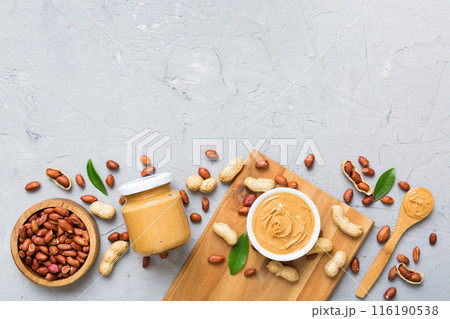 Bowl of peanut butter and peanuts on table background. top view with copy space. Creamy peanut pasta in small bowl Bowl of peanut butter and peanuts on table background. top view with copy space. Creamy peanut pasta in small bowl 116190538