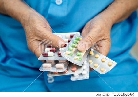 Senior Asian woman holding capsule pills drug in blister packaging for treatment infection patient in hospital. 116190664