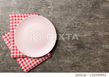 Top view on colored background empty round pink plate on tablecloth for food. Empty dish on napkin with space for your design 116190942