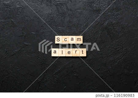 Scam alert word written on wood block. Scam alert text on table, concept 116190983