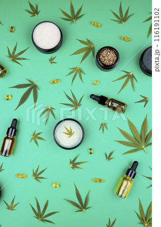 Composition with hemp oil cbd and bottle of oil on green background Composition with hemp oil cbd and bottle of oil on green background 116191102