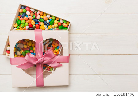 Box with sweet chocolate candies on color background, Various candy sweets. Valentines day gift box. Top view flat lay with copy space Box with sweet chocolate candies on color background, Various candy sweets. Valentines day gift box. Top view flat lay with copy space 116191476