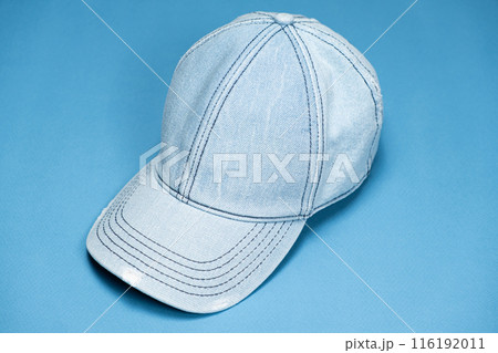Blue denim cap close-up on blue background. 116192011