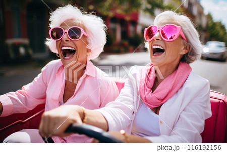 Company of elderly girlfriends of pensioners on a trip ride a convertible car and have fun 116192156