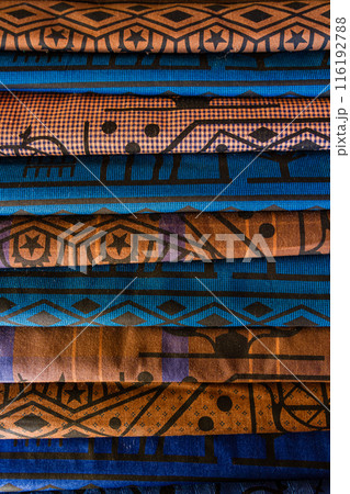 Close up of stacked colorful traditional fabric with intricate patterns, including geometric shapes and star motifs, in Turkey. Close up of stacked colorful traditional fabric with intricate patterns, including geometric shapes and star motifs, in Turkey. 116192788