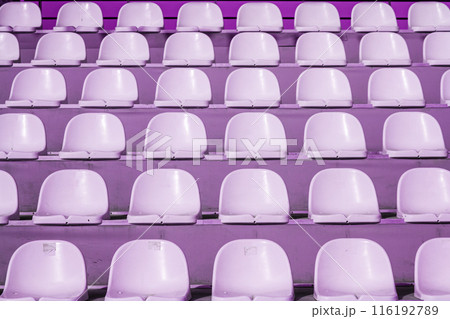 Empty rows of purple stadium seats in an outdoor setting, texture, background. Empty rows of purple stadium seats in an outdoor setting, texture, background. 116192789