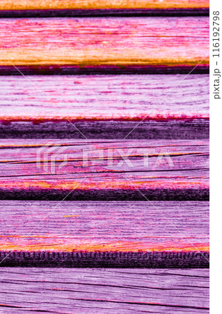 Close up of colorful wooden planks with a vibrant orange and purple hue, texture-background. 116192798