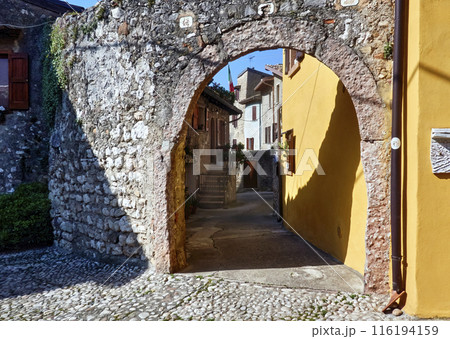 Historic brick arch gateway in the narrow alley of the small Italian town Malcesine on Lake Garda 116194159
