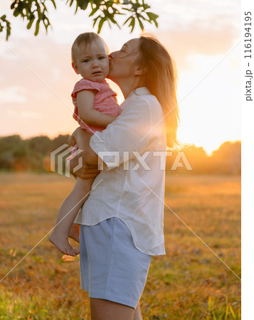 Cutie moment with woman and her little daughter outdoor with sunset tones in park Cutie moment with woman and her little daughter outdoor with sunset tones in park 116194195