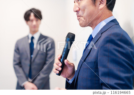 マイクを使って演説をする中年の男性 116194665