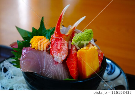 お刺身やカニ爪が乗った海鮮丼 116198433