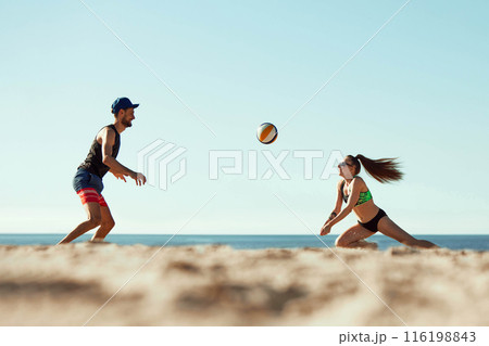 Energetic beach volleyball scene with a man and woman competing under the summer sun. Dynamic image of young man and woman 116198843