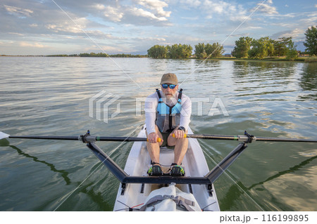 senior man in a rowing shell on a calm lake in Colorado in summer scenery senior man in a rowing shell on a calm lake in Colorado in summer scenery 116199895