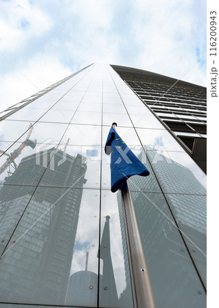 The flag of the European Union is reflected in the glass of a skyscraper. 116200943