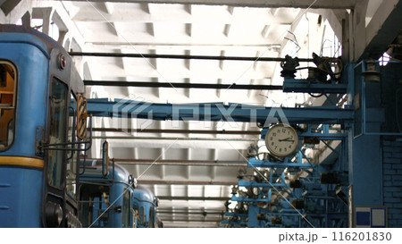 Retro railway depot with high white ceiling, fittings and clock. Metro trains in the depot. Retro railway depot with high white ceiling, fittings and clock. Metro trains in the depot. 116201830