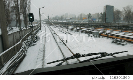 The train goes to the green light. Snow-covered subway tracks. Public transport in the great city. The train goes to the green light. Snow-covered subway tracks. Public transport in the great city. 116201860