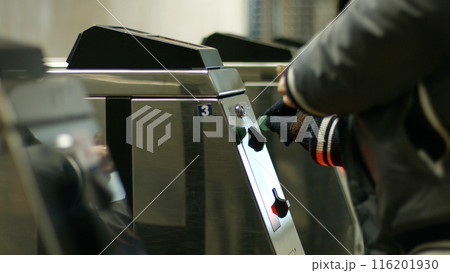 Turnstile to the metro station. People use the token to pay for their fare. Turnstile to the metro station. People use the token to pay for their fare. 116201930