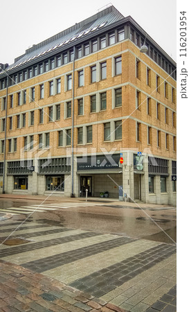 Orange brick building corner of Steinway Piano Gallery in Helsinki bottom up view from wet road with road crossing 116201954
