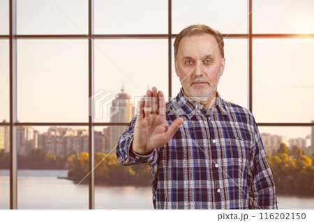 Portrait of a handsome serious confident man shows no gesture sign. Checkered windows backgorund with evening sunlight. Portrait of a handsome serious confident man shows no gesture sign. Checkered windows backgorund with evening sunlight. 116202150