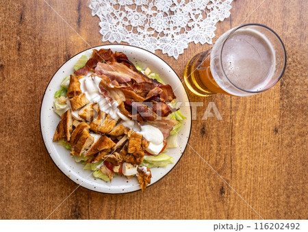 Polish Caesar salad with chicken, bacon and vegetables, high-calorie meat salad with fresh vegetables 116202492