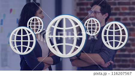 Image of multiple web globe icons floating against diverse man and woman smiling at office 116207567