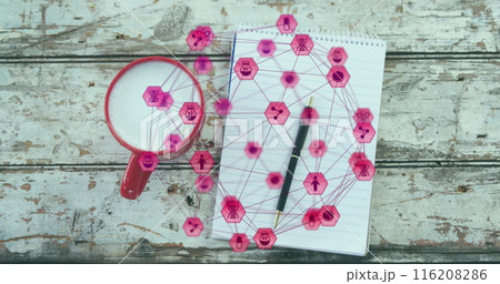 A close-up of a coffee cup, notepad, and pen on a wooden plank, with an image of a network of connec 116208286