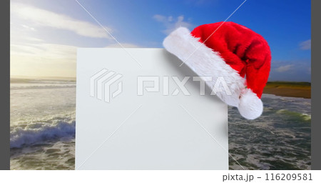 Digital composite of Santa hat with white card and sea Digital composite of Santa hat with white card and sea 116209581