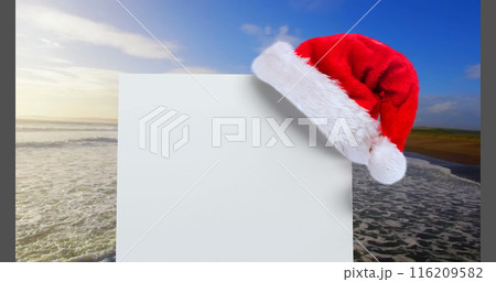 Digital composite of Santa hat with white card and sea 116209582