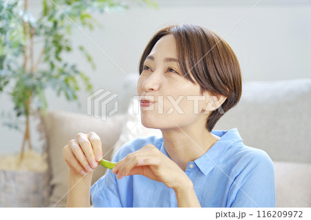 自宅で枝豆を食べる女性 116209972
