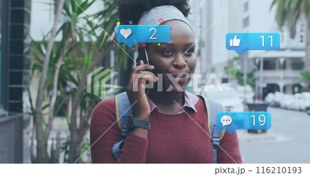 Image of social media icons and data over african american woman using smartphone Image of social media icons and data over african american woman using smartphone 116210193