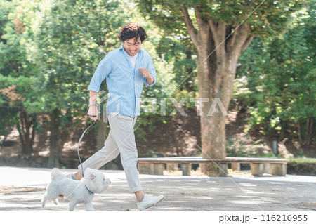 公園で犬の散歩をする中年・ミドルの日本人男性(走る) 公園で犬の散歩をする中年・ミドルの日本人男性(走る) 116210955