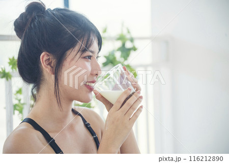 Women hands holding white glass of milk pouring from bottle. Asian women smile laugh look at camera health care home fitness lifestyle. Beautiful female drinking fresh milk low-fat dairy free lactose Women hands holding white glass of milk pouring from bottle. Asian women smile laugh look at camera health care home fitness lifestyle. Beautiful female drinking fresh milk low-fat dairy free lactose 116212890