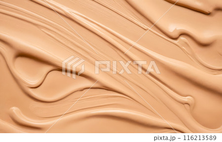 Beige foundation makeup texture swiped on surface, creamy cosmetic product wave pattern, closeup view of skin tone beauty enhancer for smooth complexion 116213589