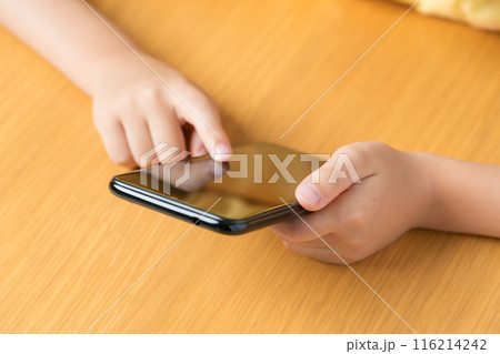 スマホをいじる子どもの手元 116214242