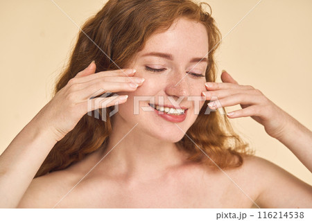 Woman Applying Skincare Cream on Face Woman Applying Skincare Cream on Face 116214538