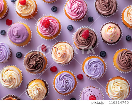 A delightful array of colorful cupcakes with various frostings and berries, arranged on a light purple background. Perfect for dessert and celebration themes. 116214740